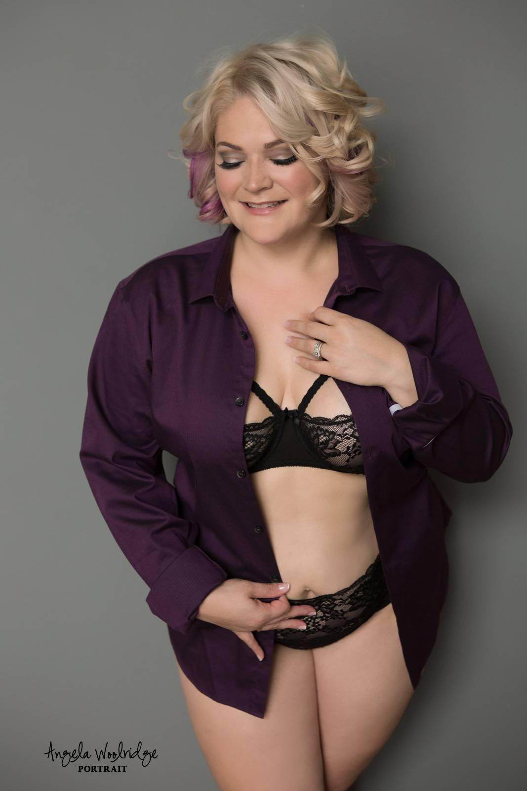 Woman in her husband's shirt in boudoir photography session