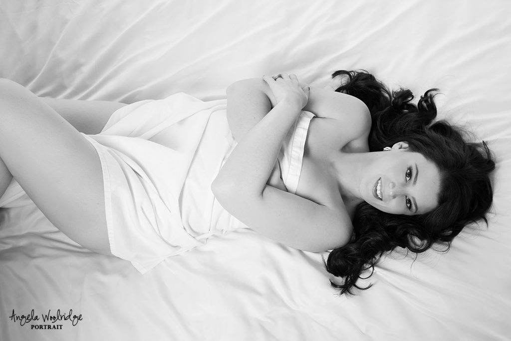Black and white of lady in white sheet boudoir session.